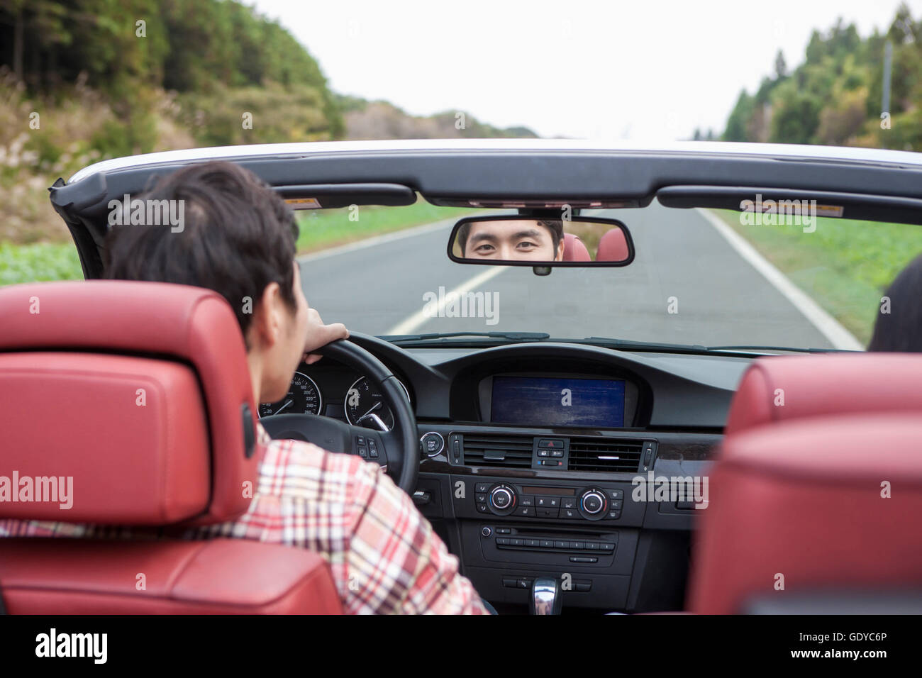 Back portrait of young man driving a car Stock Photo
