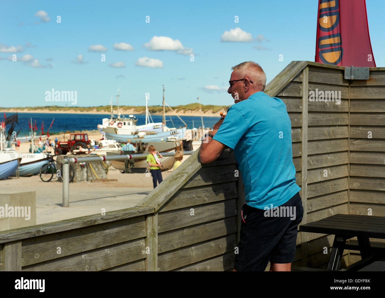 Man eating ice cream while watching (other) tourists - Nr. Vorupoer (Nr. Vorupør), Denmark Stock Photo