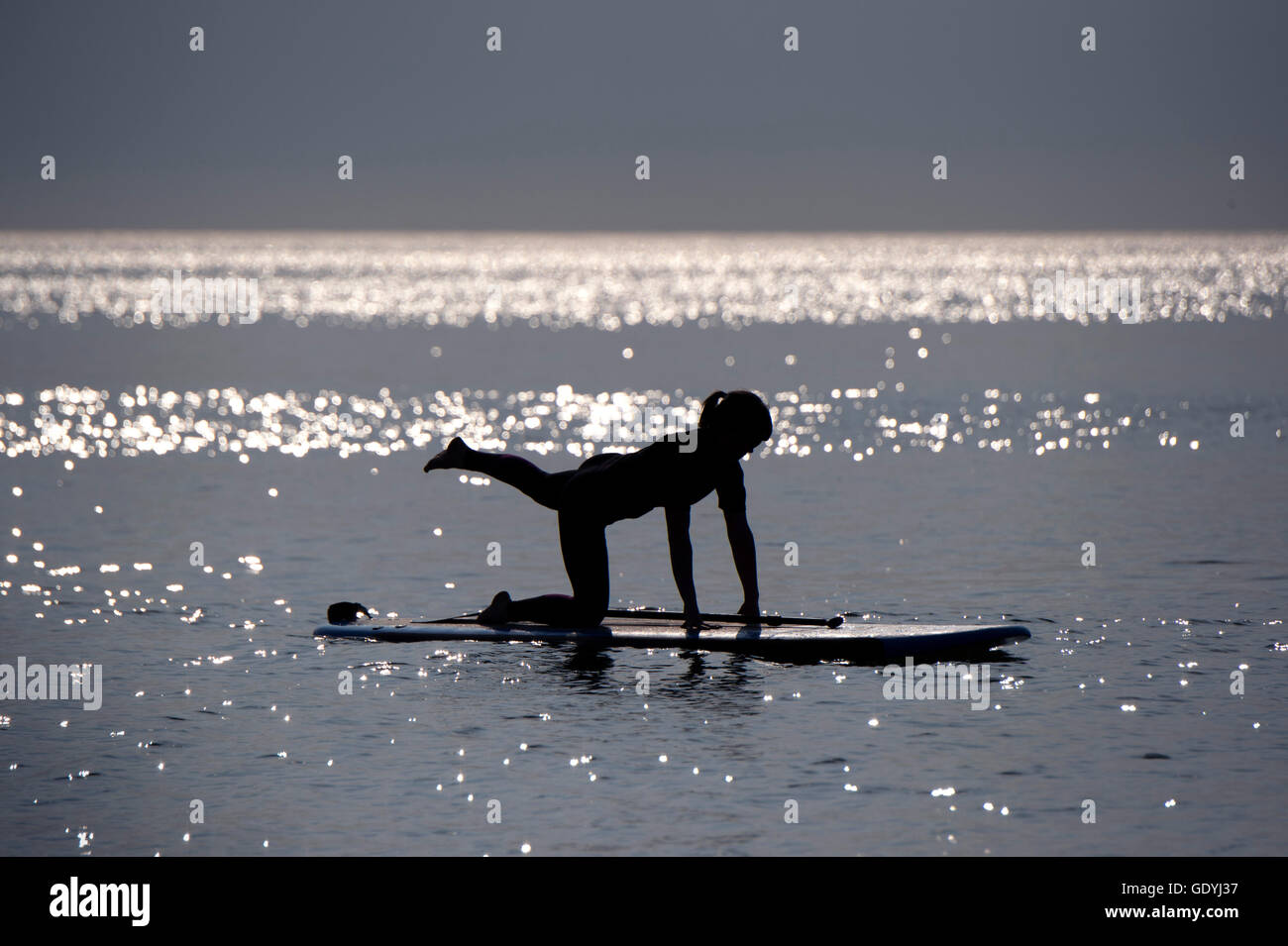 Stand-up-paddleboard (SUP) yoga at Westward Ho!, Devonshire, UK, where paddleboarders practise yoga whilst standing up.a UK Stock Photo