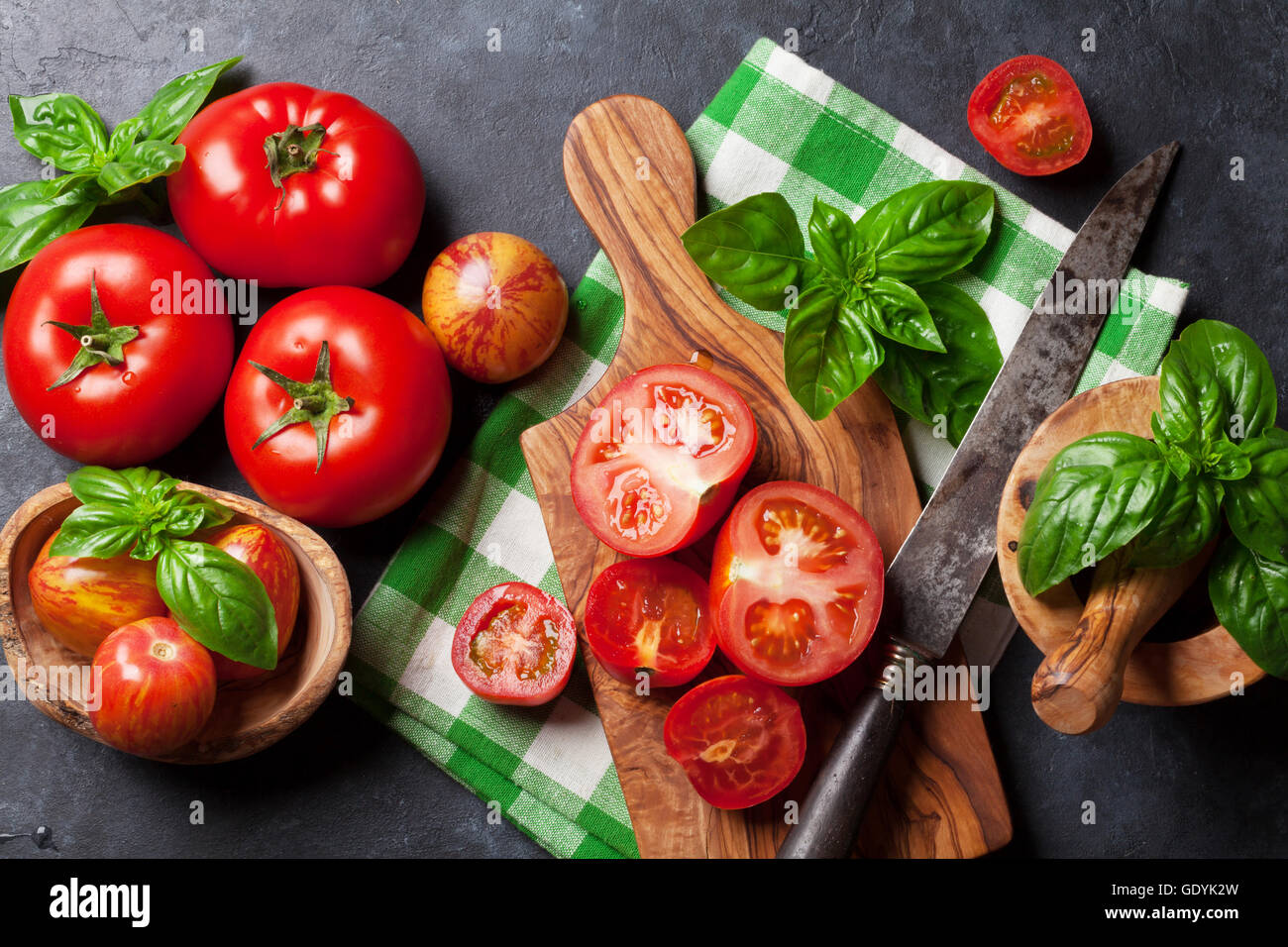 Fresh ripe garden tomatoes and basil on stone table. Top view Stock ...