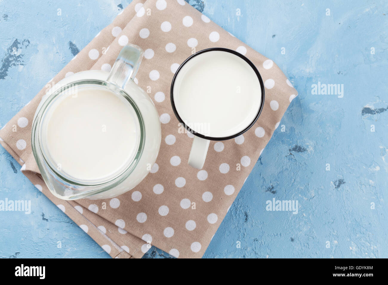 Milk jug and cup on stone table. Dairy products. Top view Stock Photo