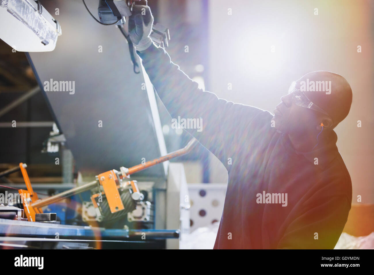 Worker operating machinery in steel factory Stock Photo