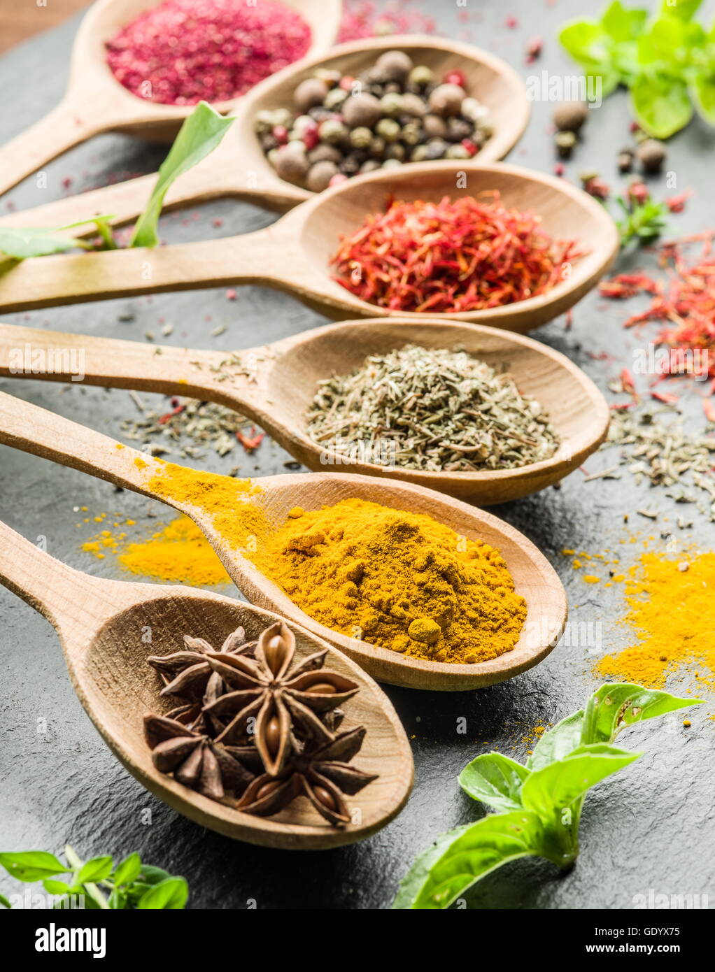 Assortment of colorful spices in the wooden spoons. Stock Photo