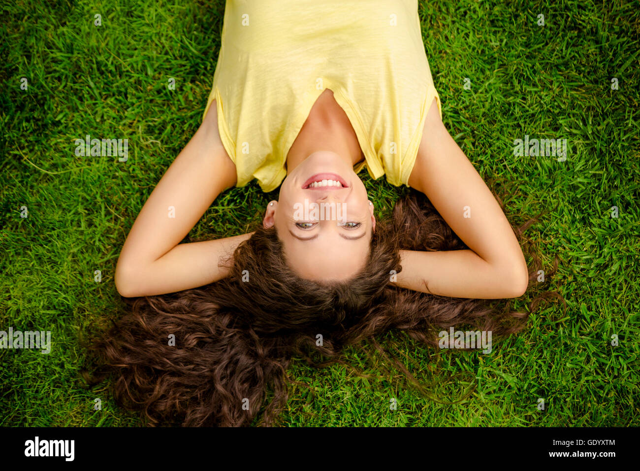 Portrait of a beautiful and happy young woman lying on the grass Stock ...