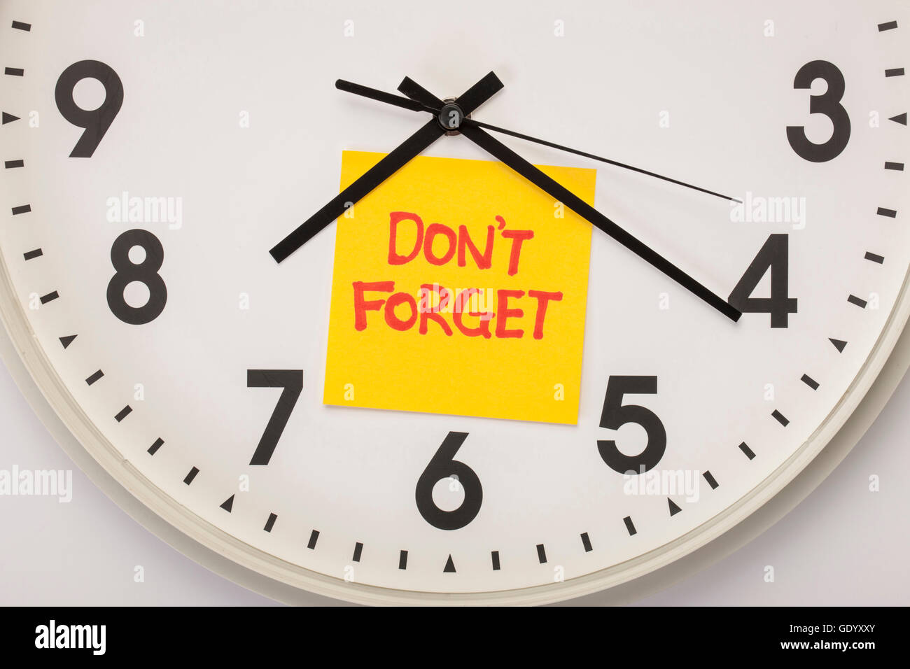 Close up of clock with message of Don't on postit Stock Photo