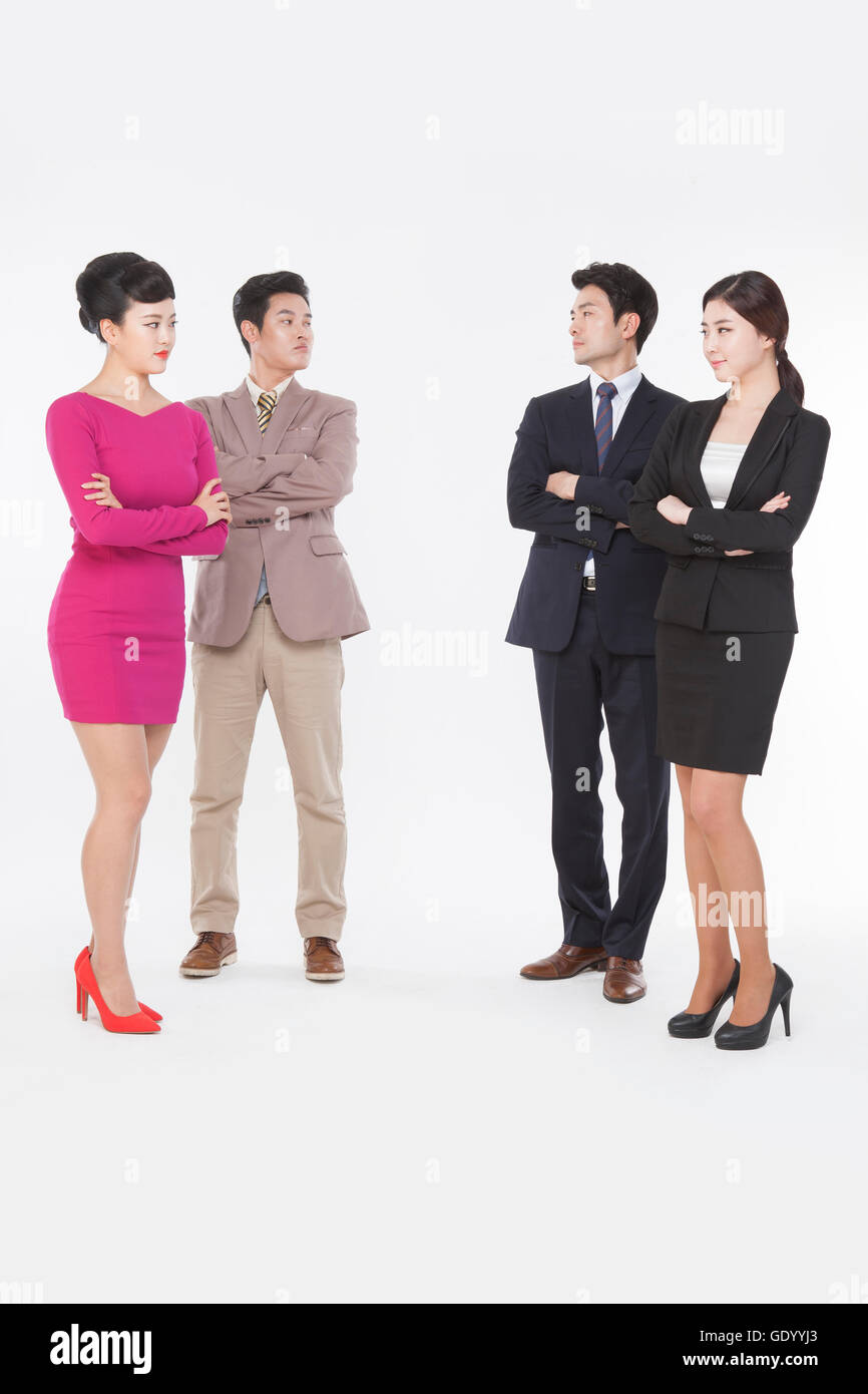 Contrasting business people in retro styles and black suits standing face to face with their arms folded Stock Photo