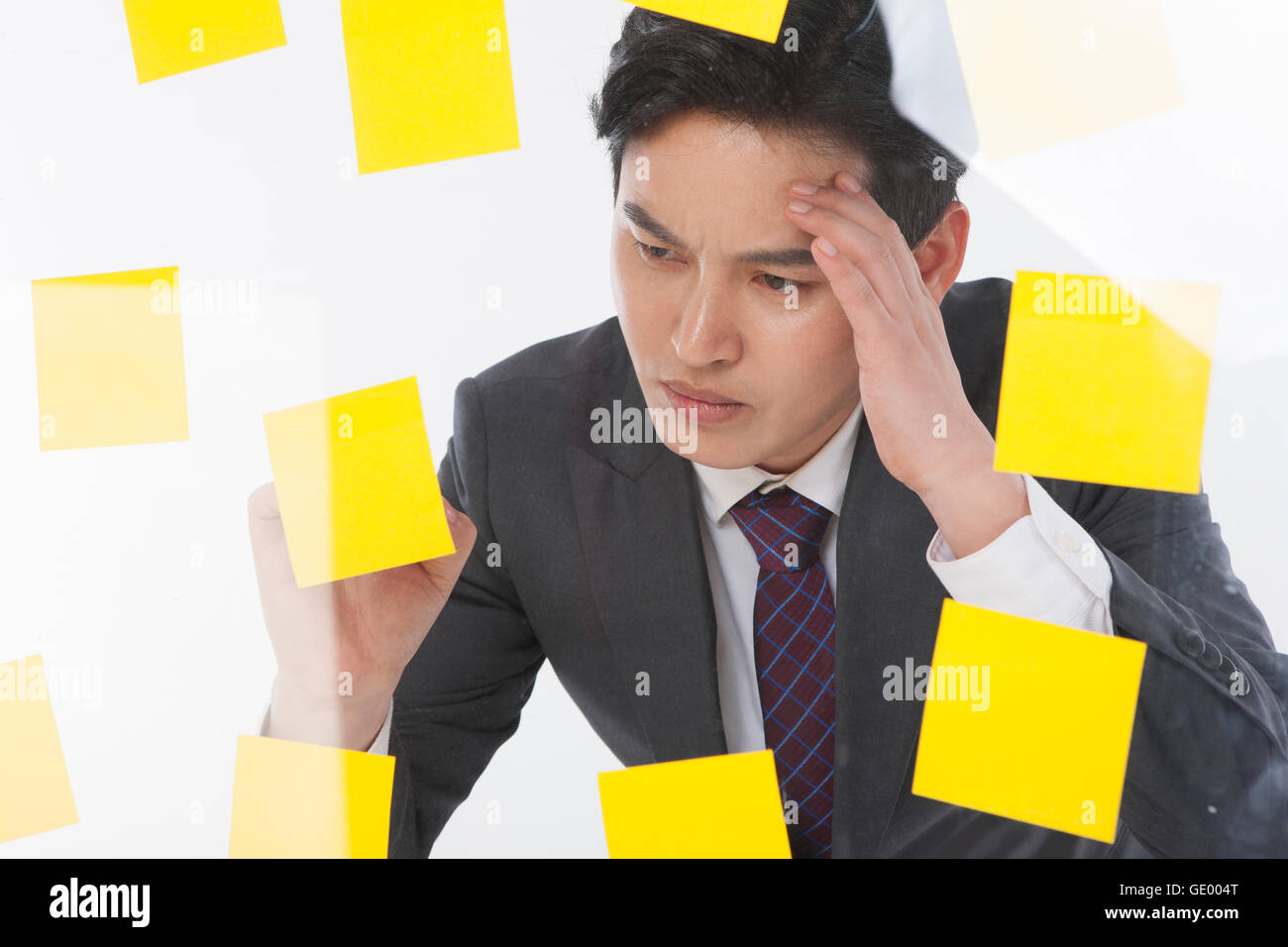 Portrait of stressful businessman with lots of post-it Stock Photo