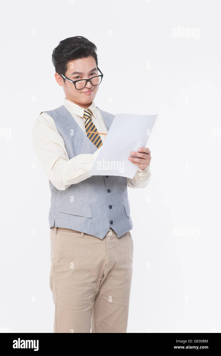 Businessman standing writing down on a paper staring at front Stock Photo