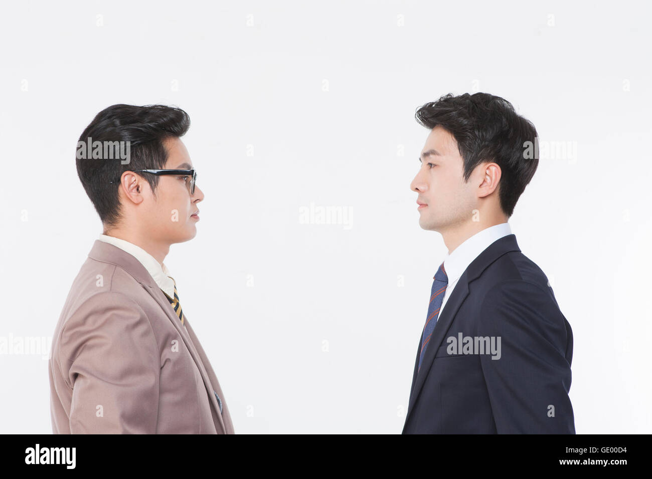 Side view portrait of two business men face to face Stock Photo