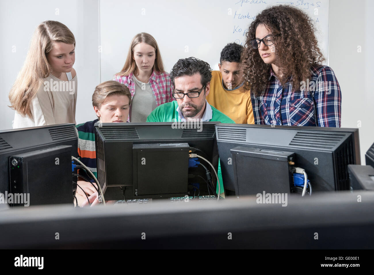 Teacher teaching students in computer lab, Bavaria, Germany Stock Photo