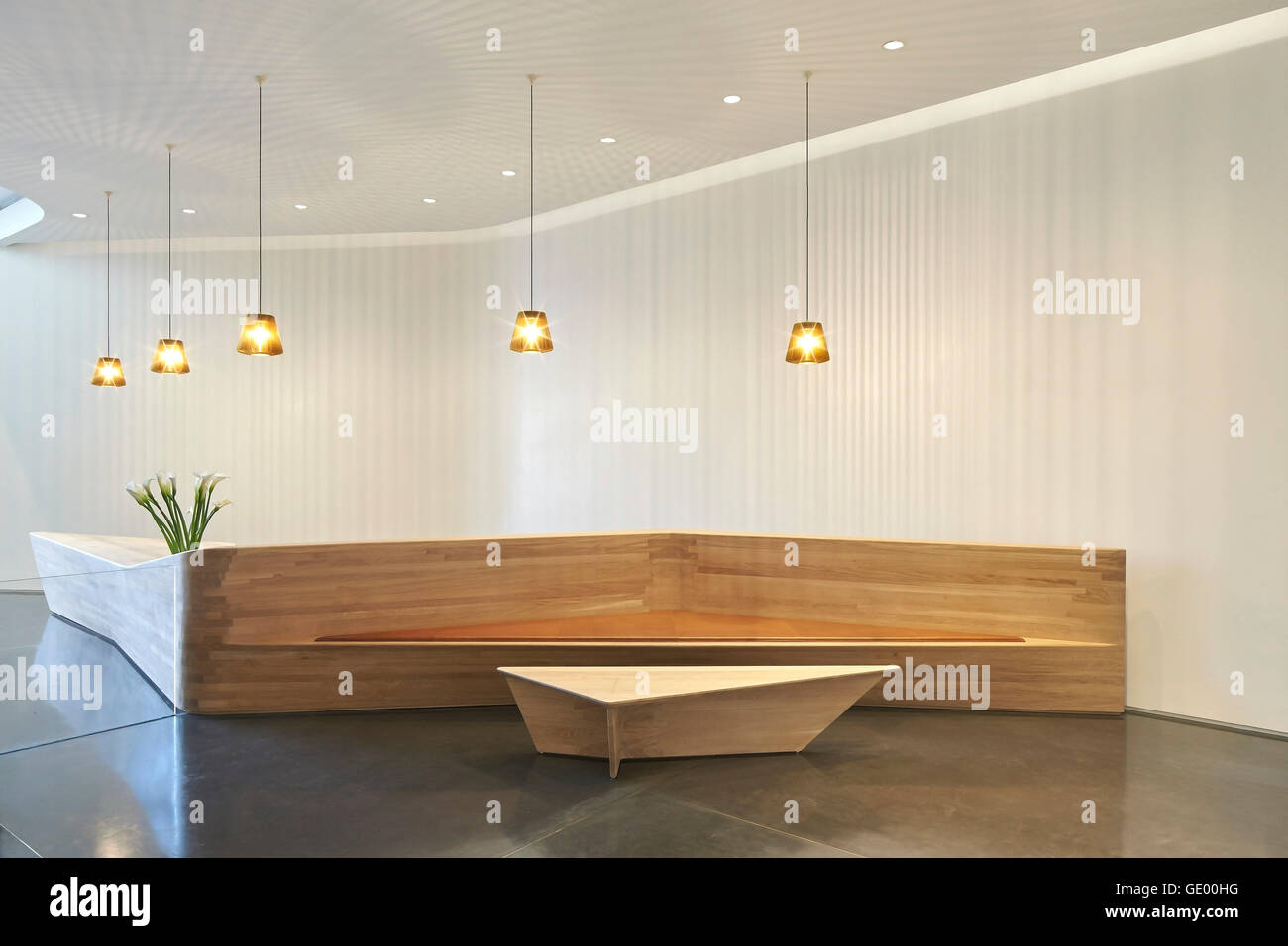 Wooden reception desk with integrated bench. Turnmill Building, London, United Kingdom. Architect: Piercy & Company, 2015. Stock Photo