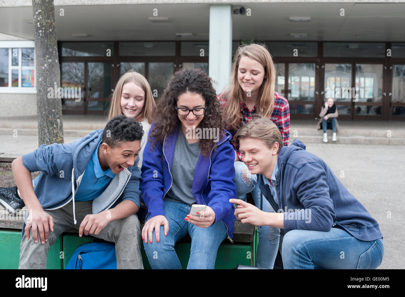 University students enjoying with mobile phone in campus, Bavaria, Germany Stock Photo