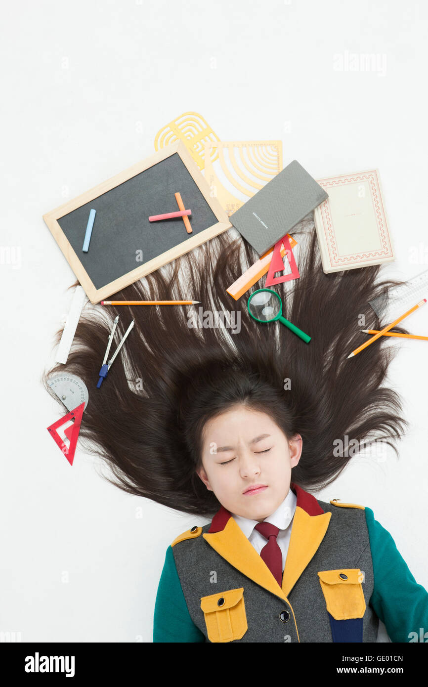 Portrait Of Stressful Middle School Girl Lying Down With School