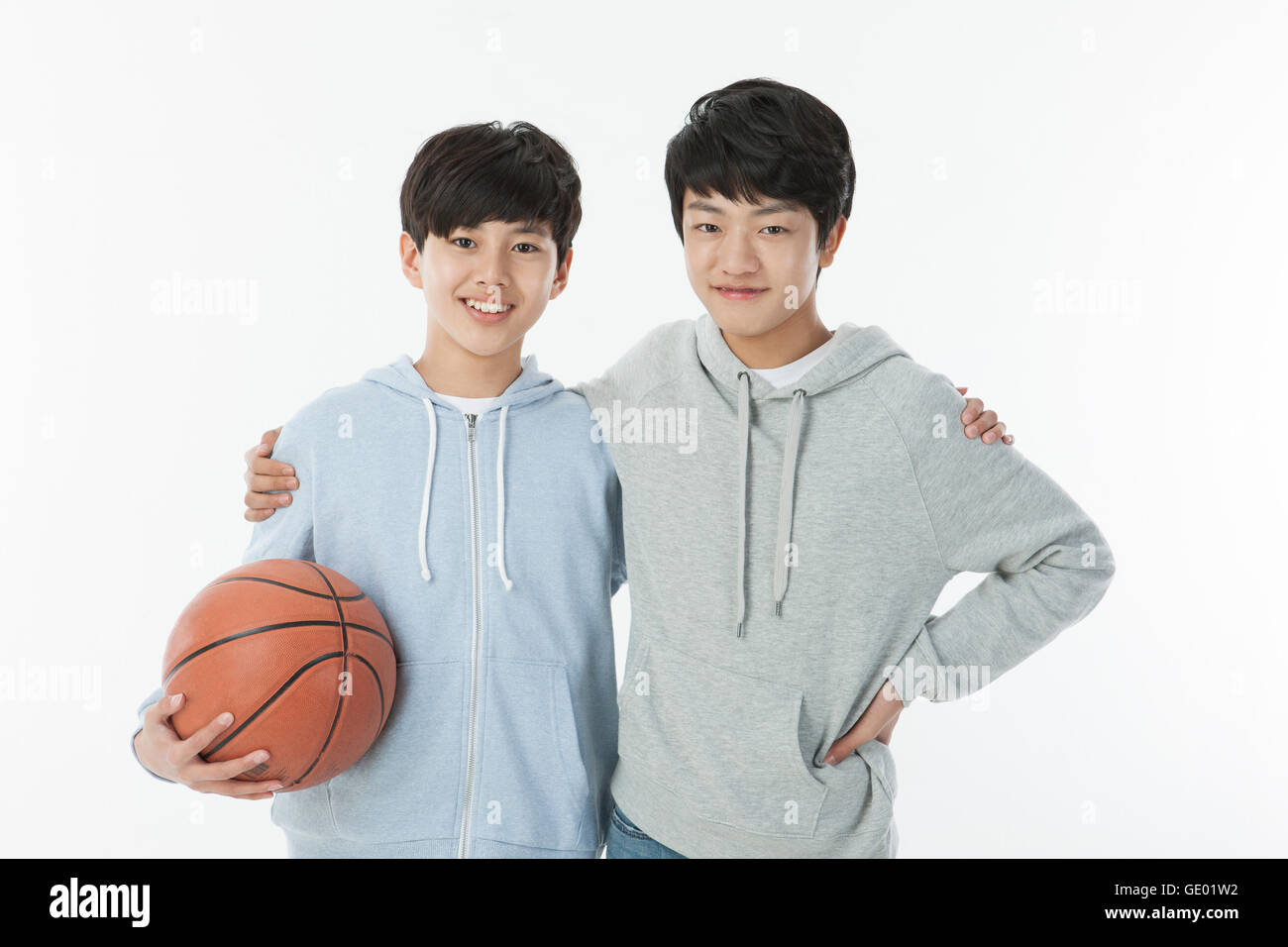 Portrait of two smiling school boys posing with a basketball Stock Photo