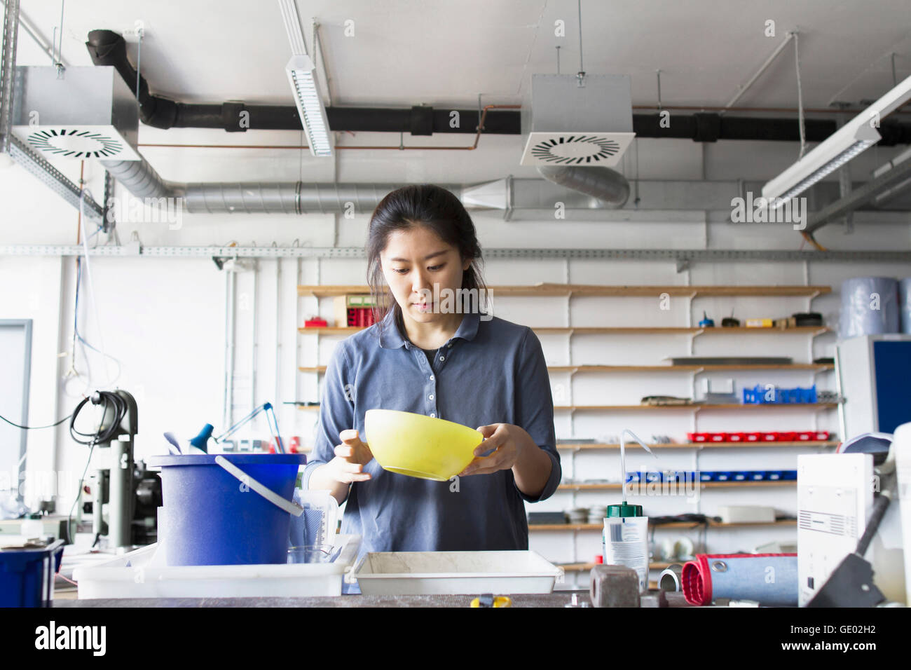 Young female engineer looking into pan in an industrial plant, Freiburg im Breisgau, Baden-Württemberg, Germany Stock Photo