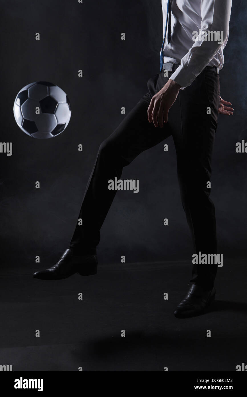Side view of bottom body parts of business man with a soccer ball Stock