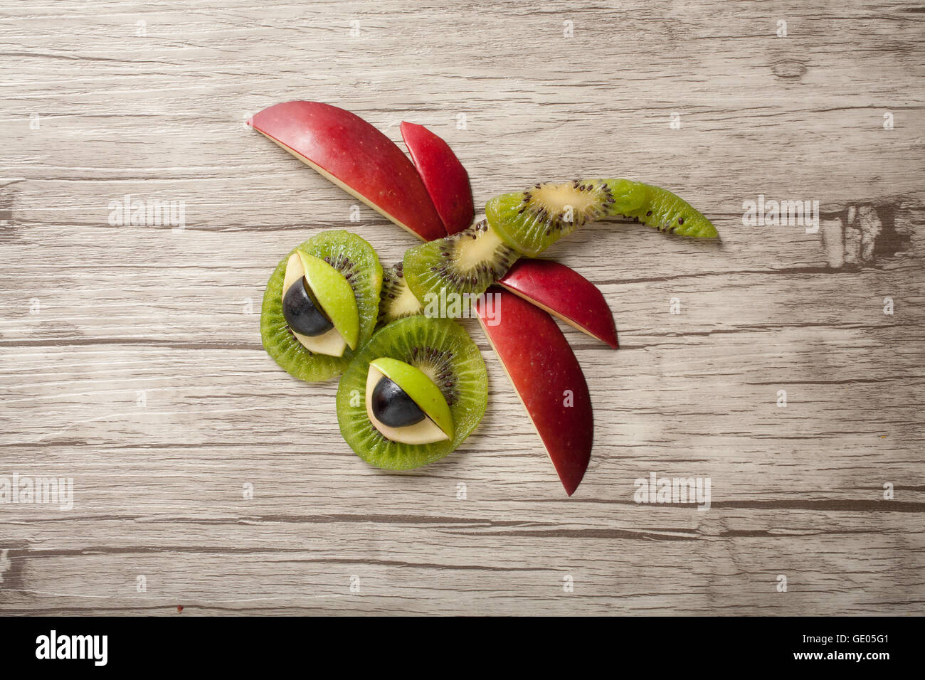 Funny dragonfly made of fruits on isolated background Stock Photo