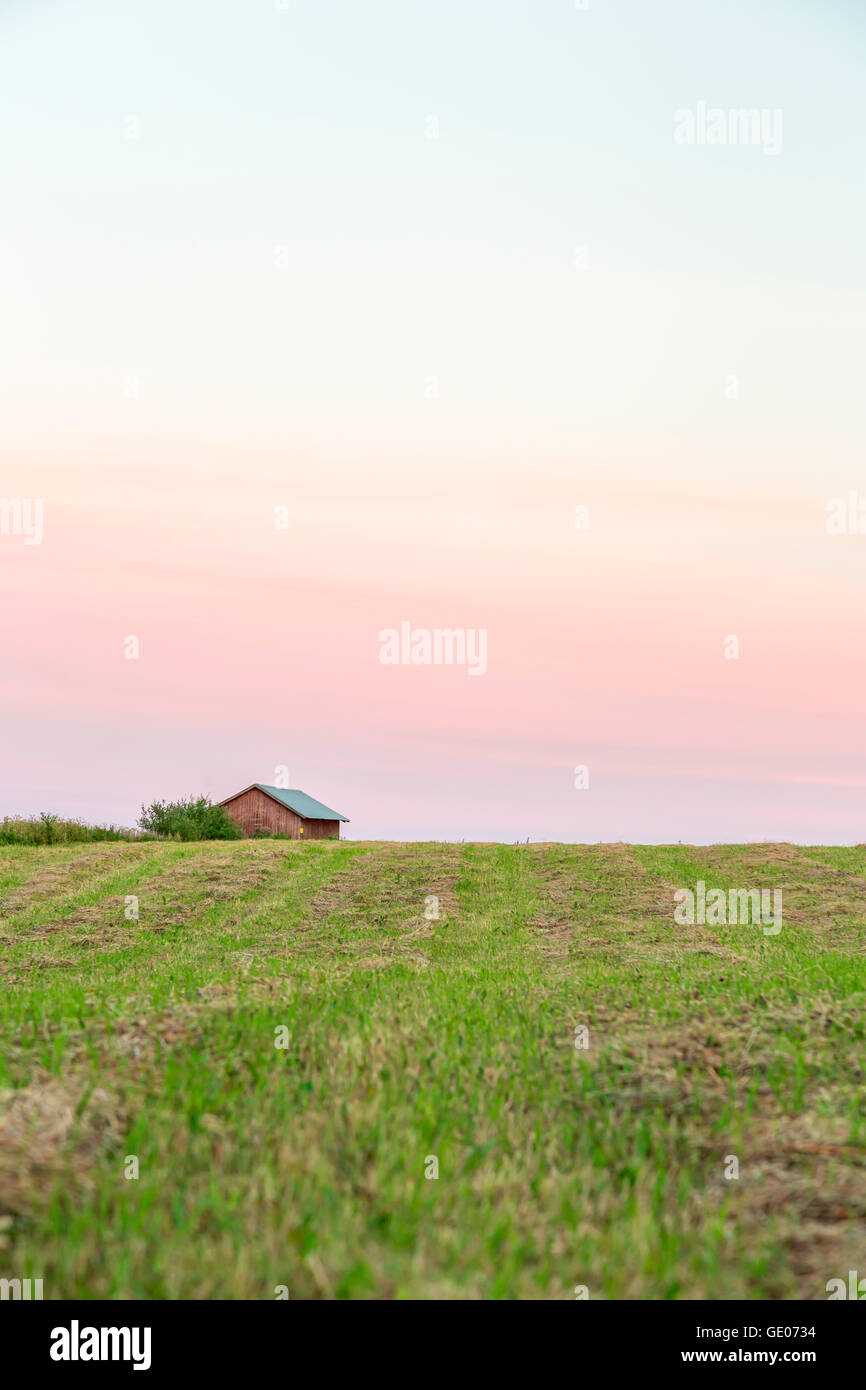 Wood Barn in Field with a partly cloudy sky. Stock Photo