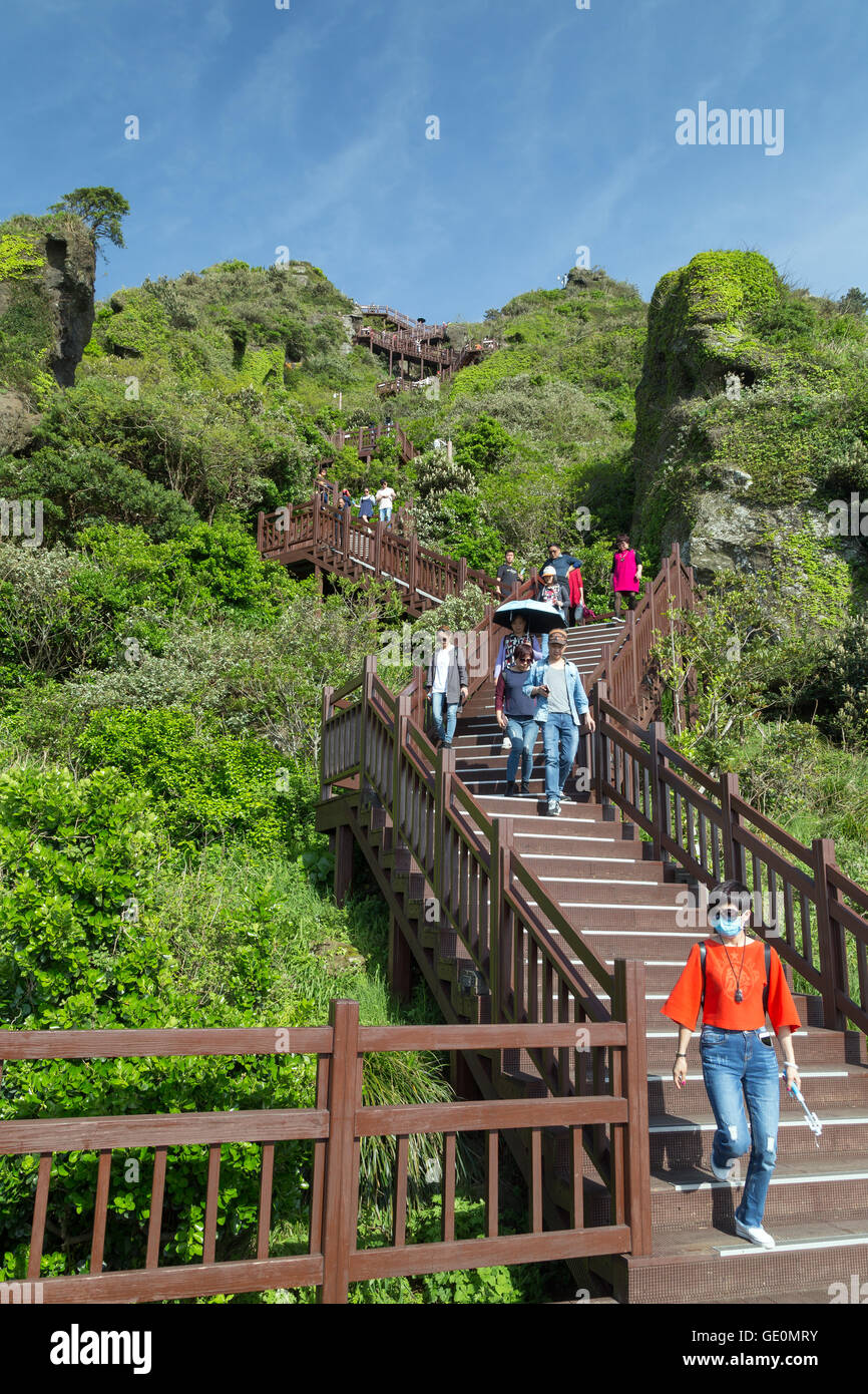 View of people climbing down the stairs at the Seongsan Ilchulbong Peak on Jeju Island in South Korea. Stock Photo
