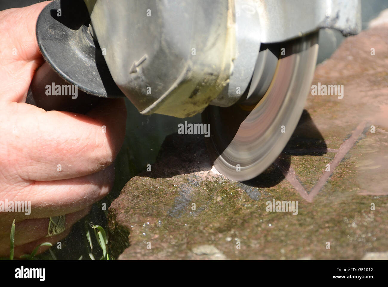 Cutting in a stone with a grinder. This is going to be the memory of my loved dog Blistay (AY seen in the picture) Stock Photo