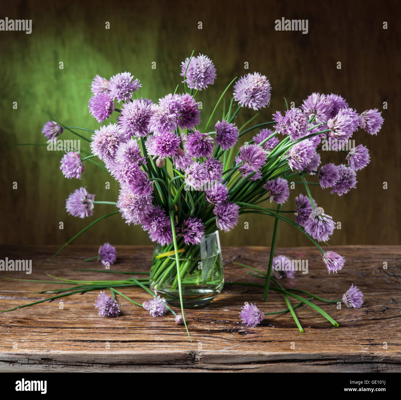 Bouquet of onion (chives) flowers in the vase on the wooden table Stock