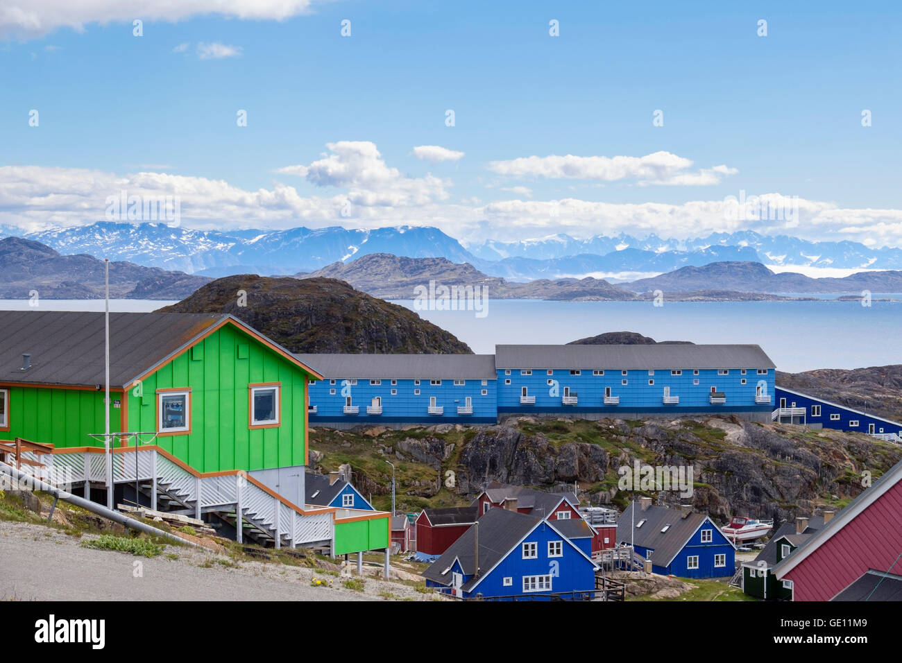 Colourful modern housing built on a hillside with view of coast and mountains. Sisimiut (Holsteinsborg) Qeqqata West Greenland Stock Photo