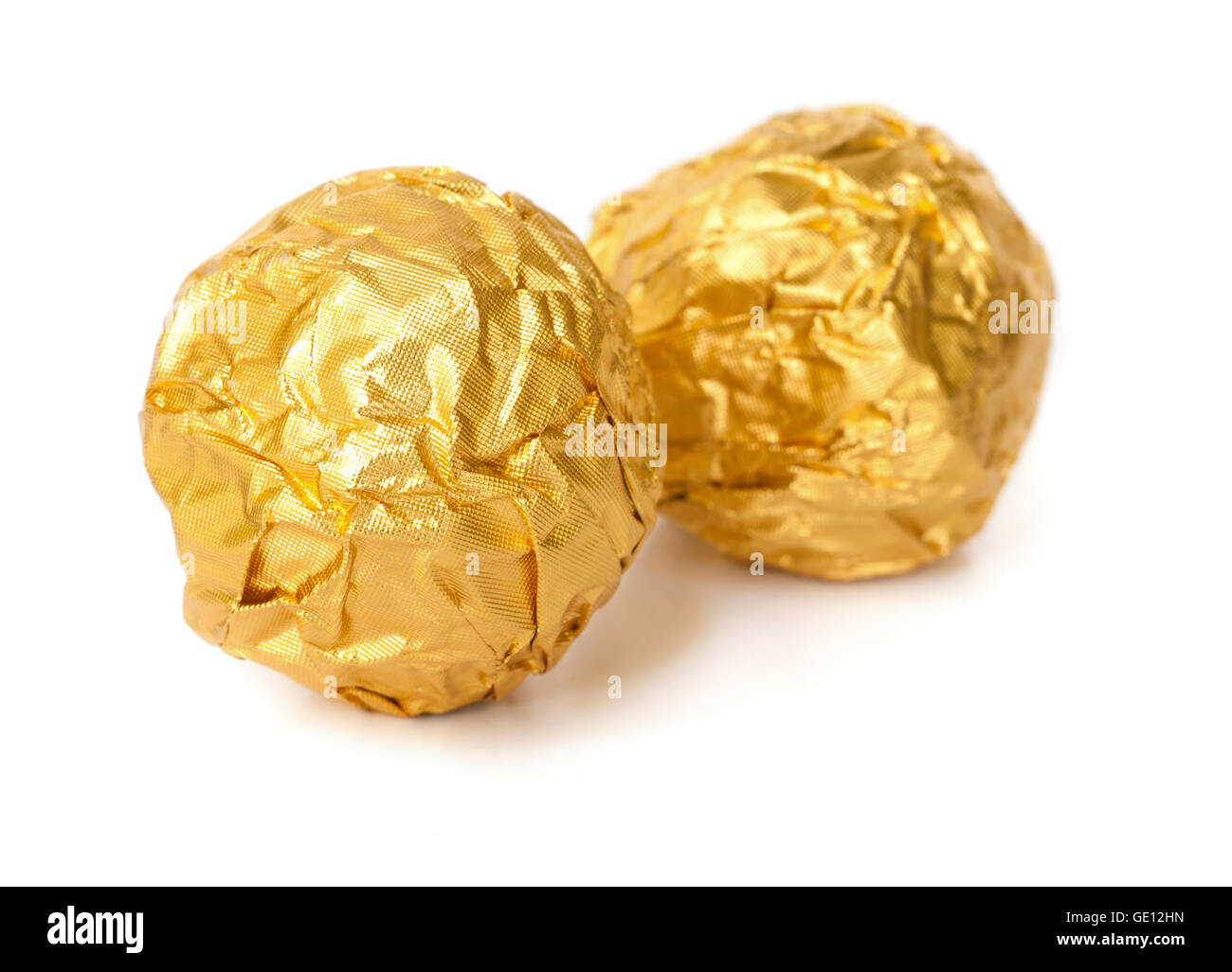 Two chocolate balls with almond  in a gold foil paper. Stock Photo