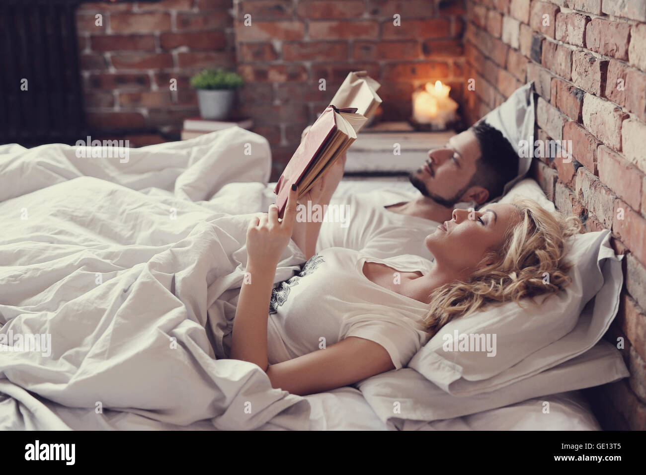Couple reading in bed wall hi-res stock photography and images - Alamy