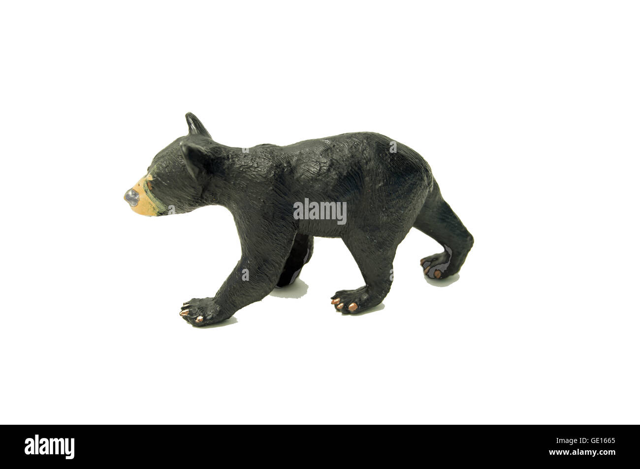 A toy hard-black plastic bear cub on a white, high key background. Stock Photo