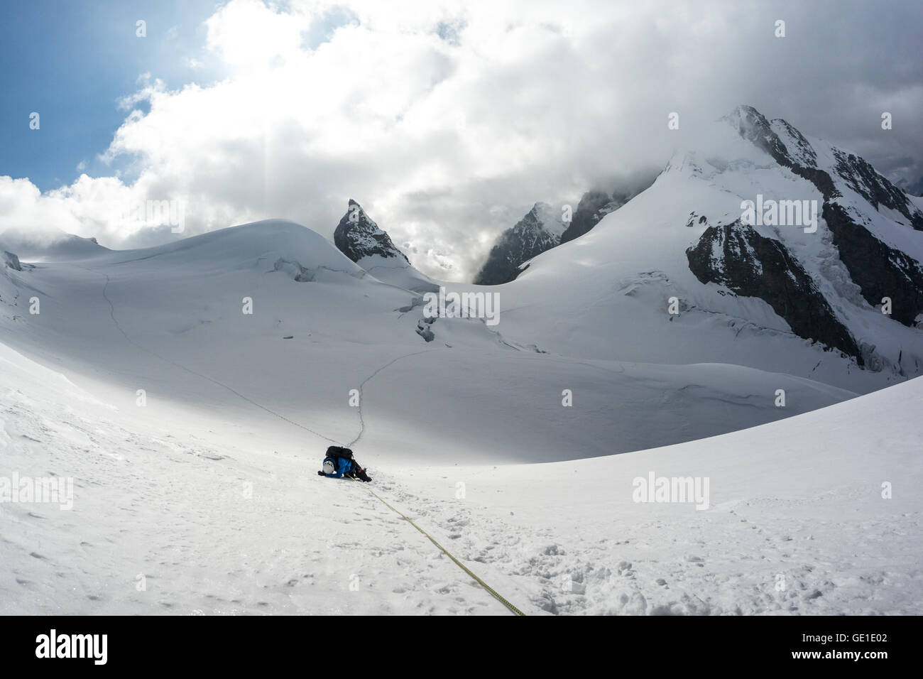 Mountain climber collapsed on snow in Swiss Alps, Piz Bernina, Switzerland Stock Photo
