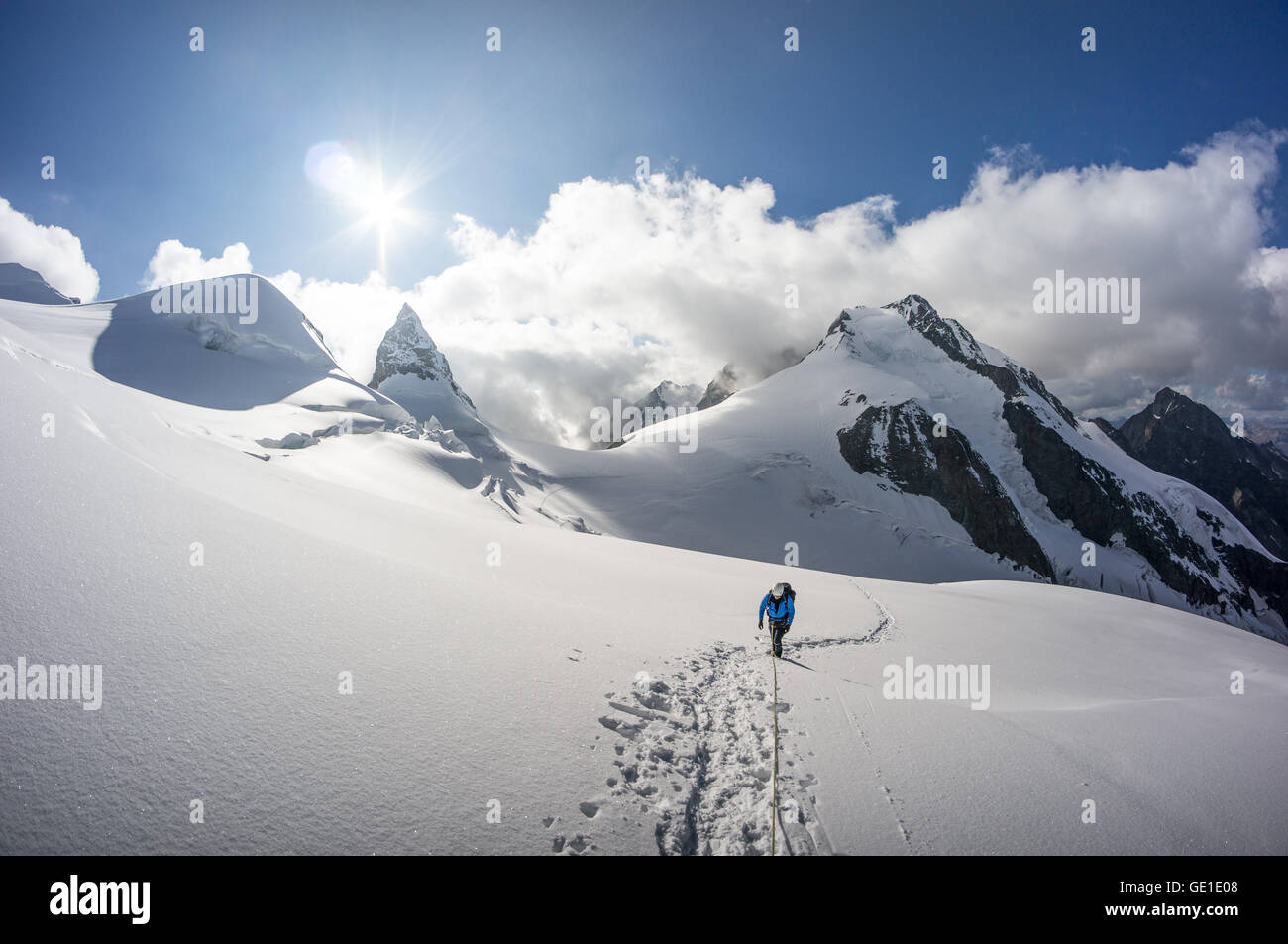 Alpinist walking on a glacier in the Swiss Alps, Piz Bernina, Switzerland Stock Photo