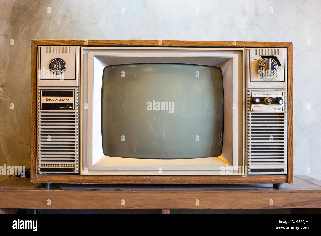 retro tv with wooden case in room with vintage wallpaper on wood table Stock Photo