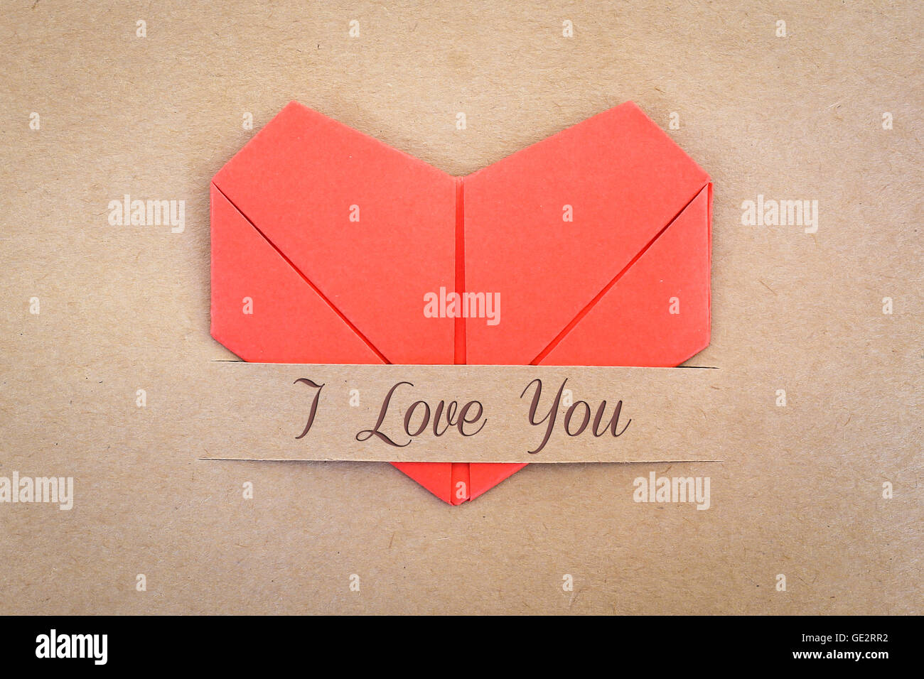 Valentine card, The red heart shape paper on brown with 'I love you' label Stock Photo