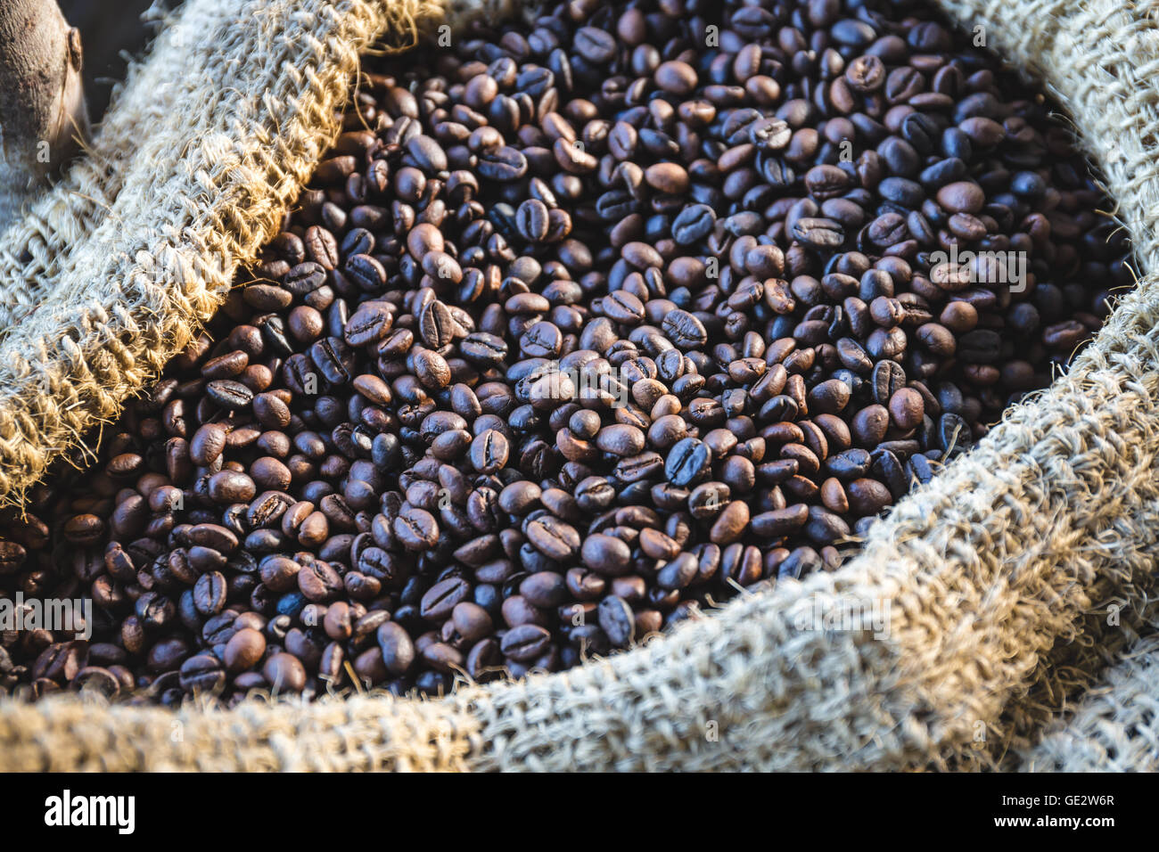 closeup coffee beans with sunlight in gunny bag Stock Photo