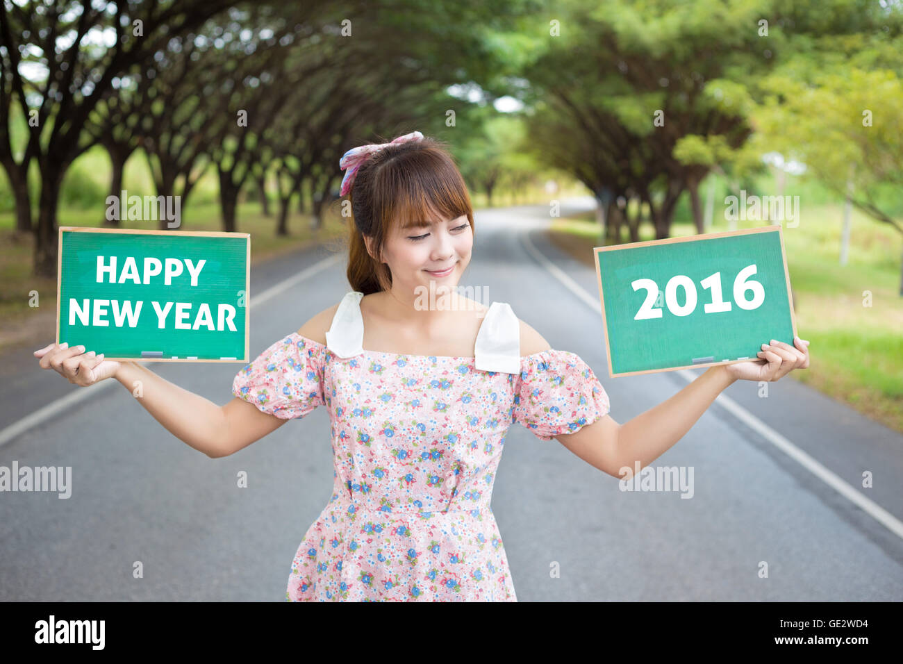 Cute woman hand holding green board sign with text " happy new year ...