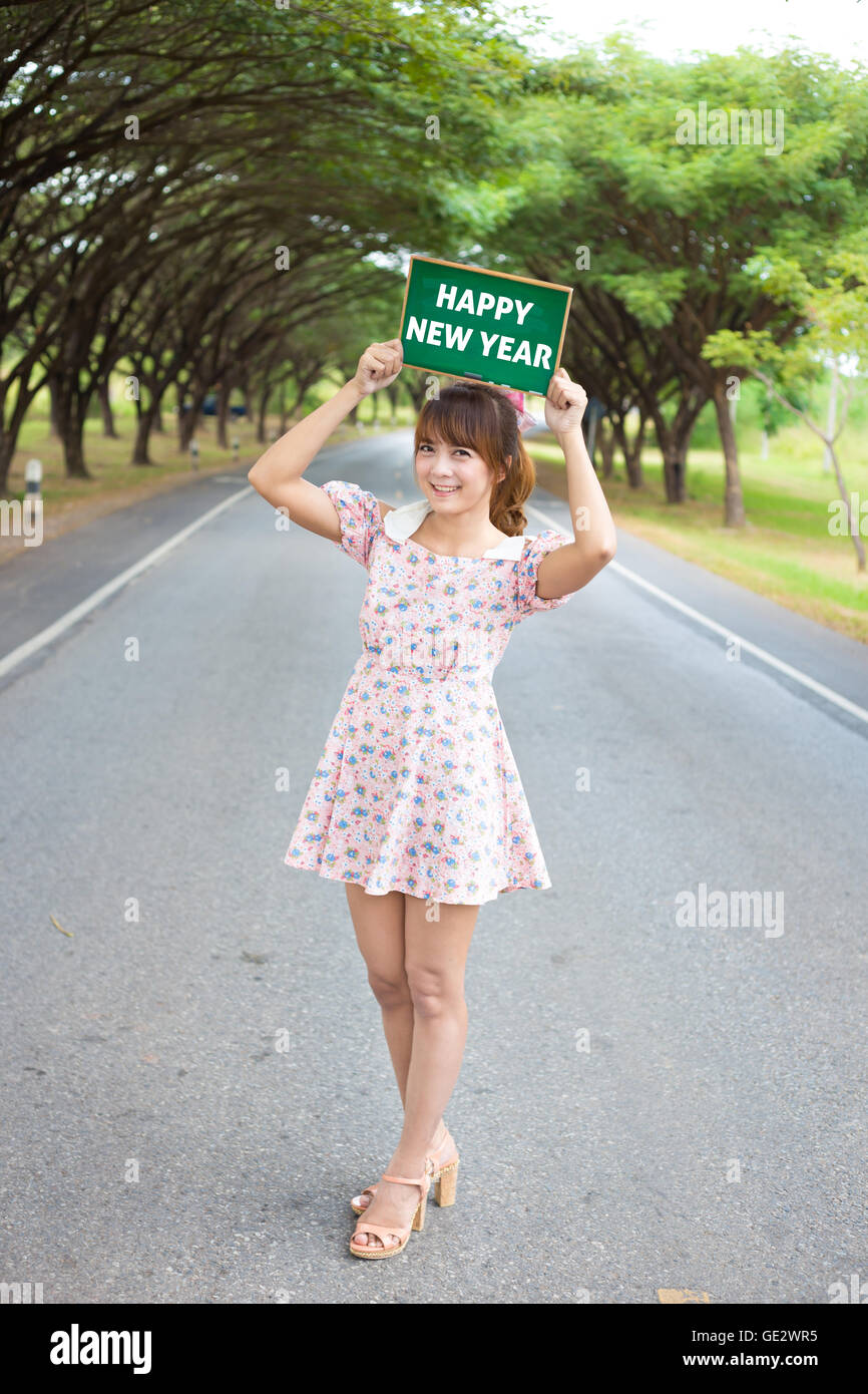 Cute woman hand holding green board sign with text " happy new year ...