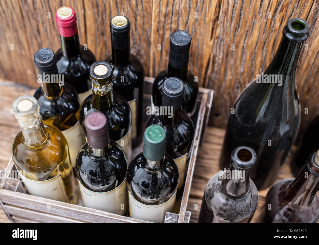 Old wine bottles in a wooden crate. Stock Photo