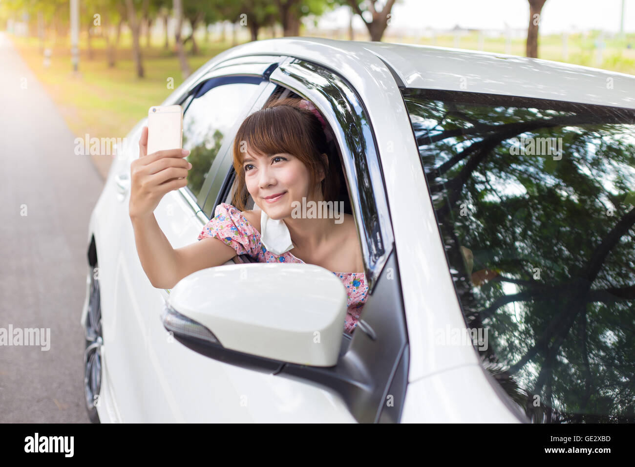 woman hand holding smartphone on window white car Stock Photo