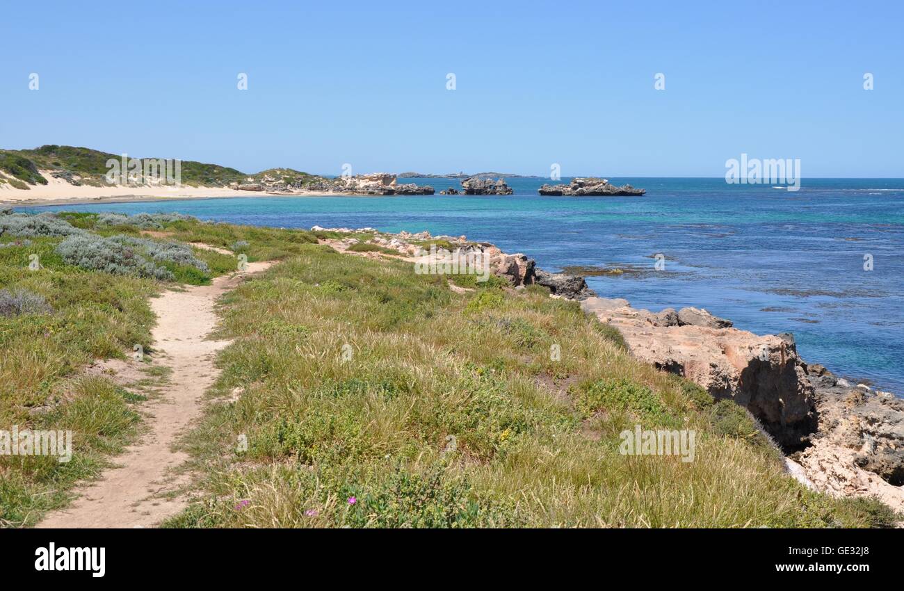 Narrow sandy path through the vegetated dunes at Point Peron with limestone rock, beach and Indian Ocean in Western Australia Stock Photo