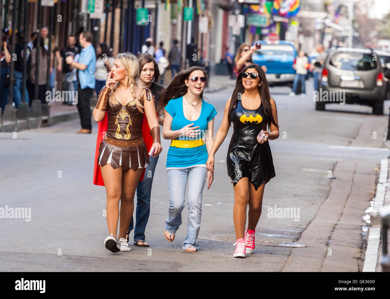 Women wearing funny costumes celebrating famous Mardi Gras carnival on the street in French Quarter. Stock Photo