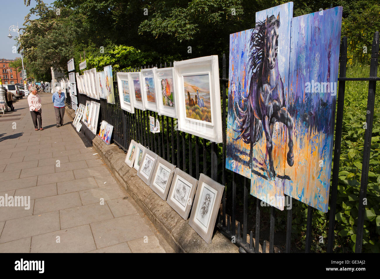 Ireland, Dublin, Merrion Square West, Sunday art market, paintings hanging on railings Stock Photo