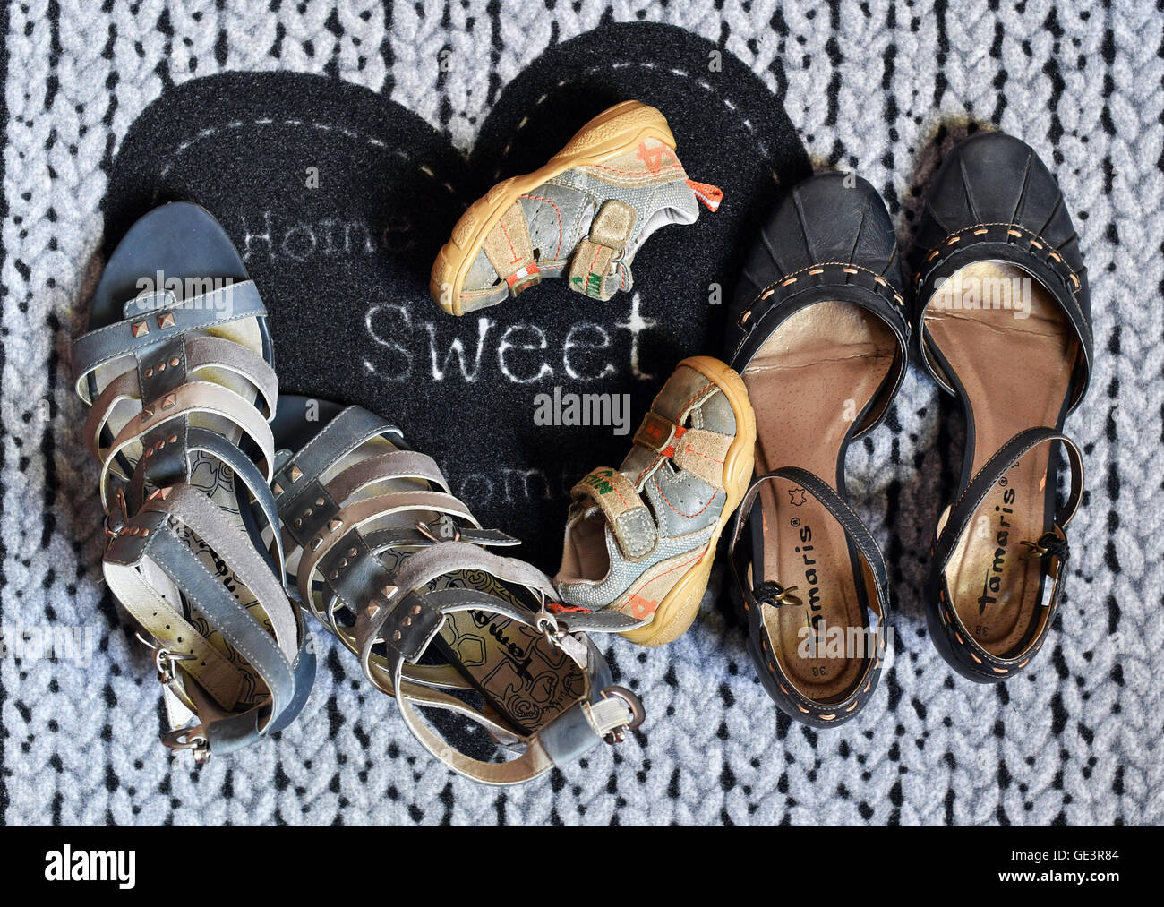 Berlin, Germany. 19th July, 2016. ILLUSTRATION - The shoes of two women and a child stand on a door mat in front of a flat in Berlin, Germany, 19 July 2016. Photo: Jens Kalaene/dpa/Alamy Live News Stock Photo