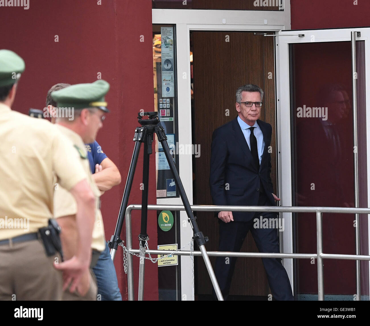 Munich, Germany. 23rd July, 2016. German Interior Minister Thomas de Maiziere (CDU) leaves a McDonald's restaurant after inspecting the crime scene near to the Olympia Einkaufszentrum (OEZ), one day after a shooting with deaths and casualties in the building, in Munich, Germany, 23 July 2016. The fatal shooting was carried out by an 18-year-old German-Iranian man. Ten people died, including the perpetrator. Photo: SVEN HOPPE/dpa/Alamy Live News Stock Photo