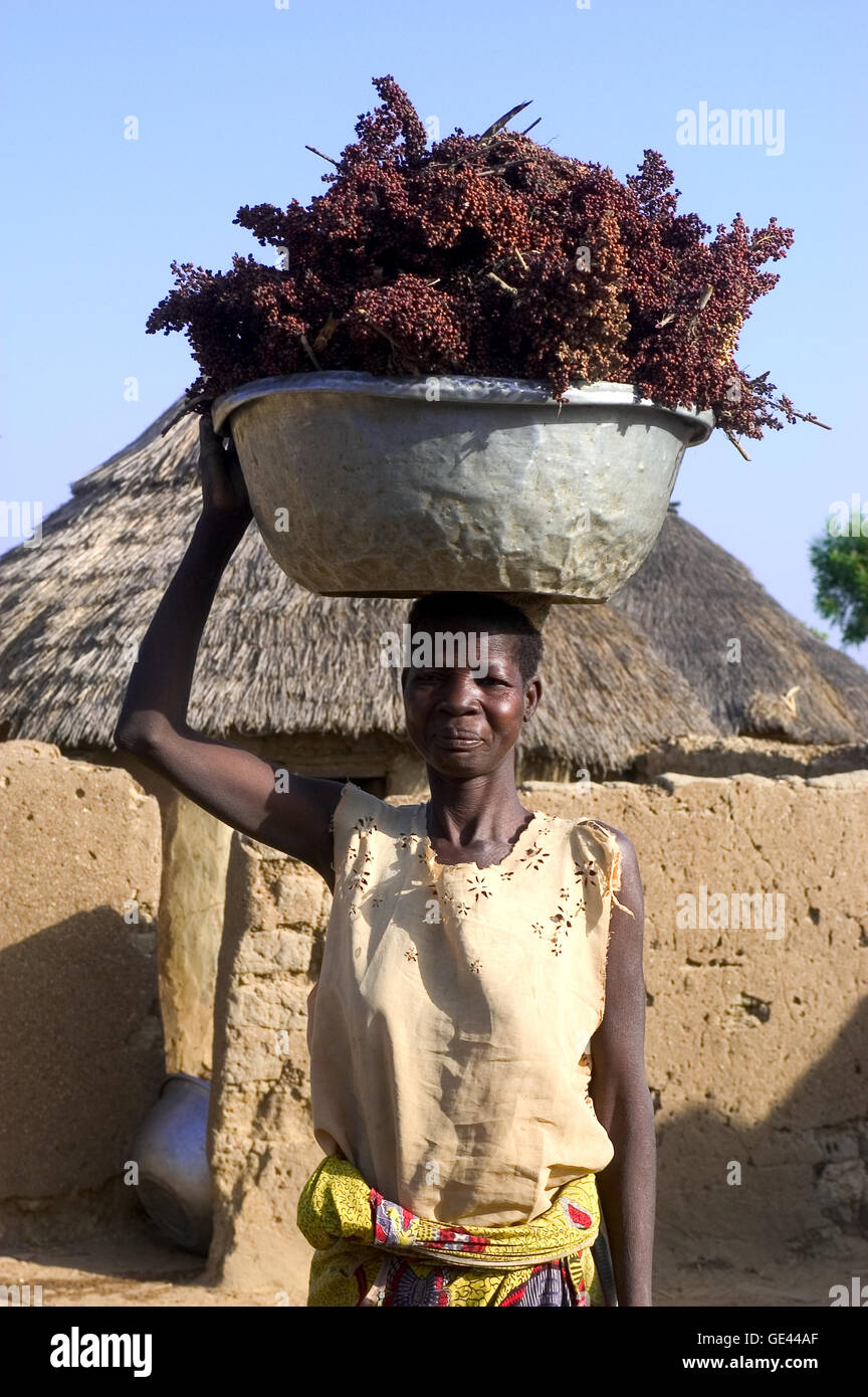 portrait of a woman in her village carrying a load on the head Stock Photo