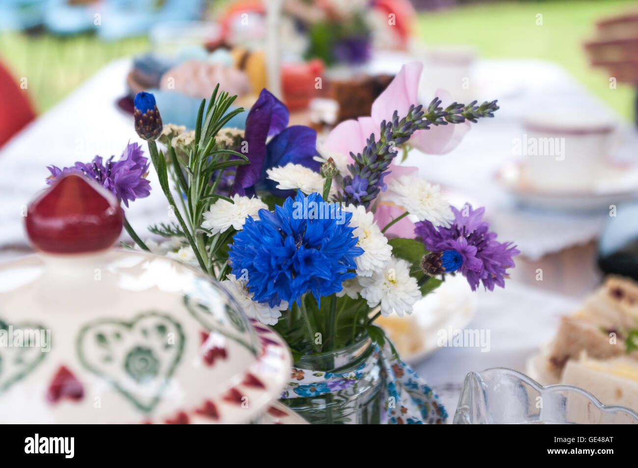 Teapot and flowers on table laid for English afternoon tea. Stock Photo