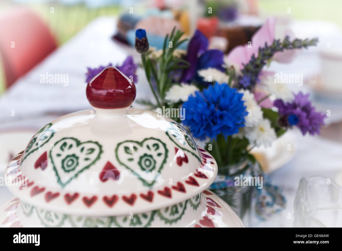 Teapot and flowers on table laid for English afternoon tea. Stock Photo