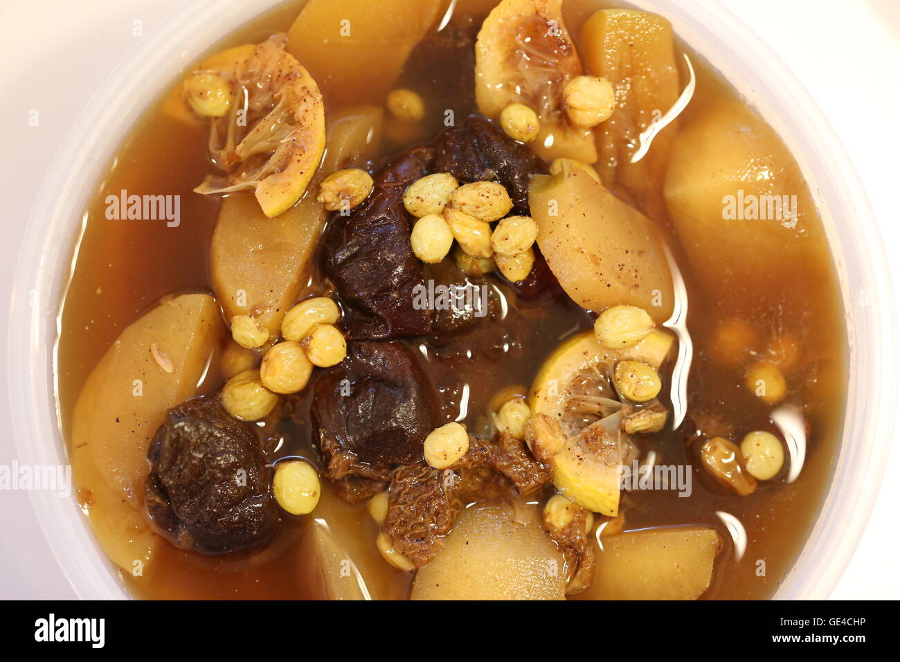 Apple compote. Apple compote with prunes and raisins, sugar syrup, cinnamon and  lemon juice, close up, top view. Stock Photo
