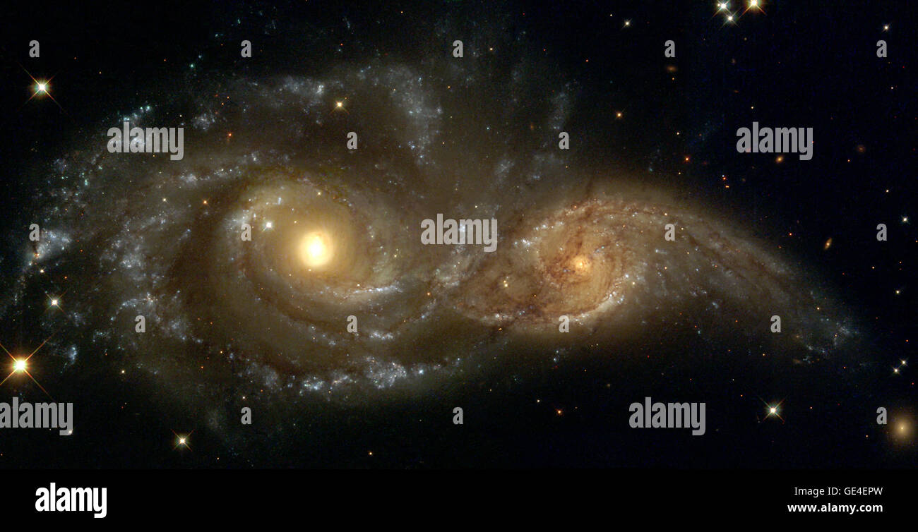 The larger and more massive galaxy is cataloged as NGC 2207 (on the left in the Hubble Heritage image), and the smaller one on the right is IC 2163. Strong tidal forces from NGC 2207 have distorted the shape of IC 2163, flinging out stars and gas into long streamers stretching out a hundred thousand light-years toward the right-hand edge of the image. Computer simulations, carried out by a team led by Bruce and Debra Elmegreen, demonstrate the leisurely timescale over which galactic collisions occur. In addition to the Hubble images, measurements made with the National Science Foundation's Ver Stock Photo