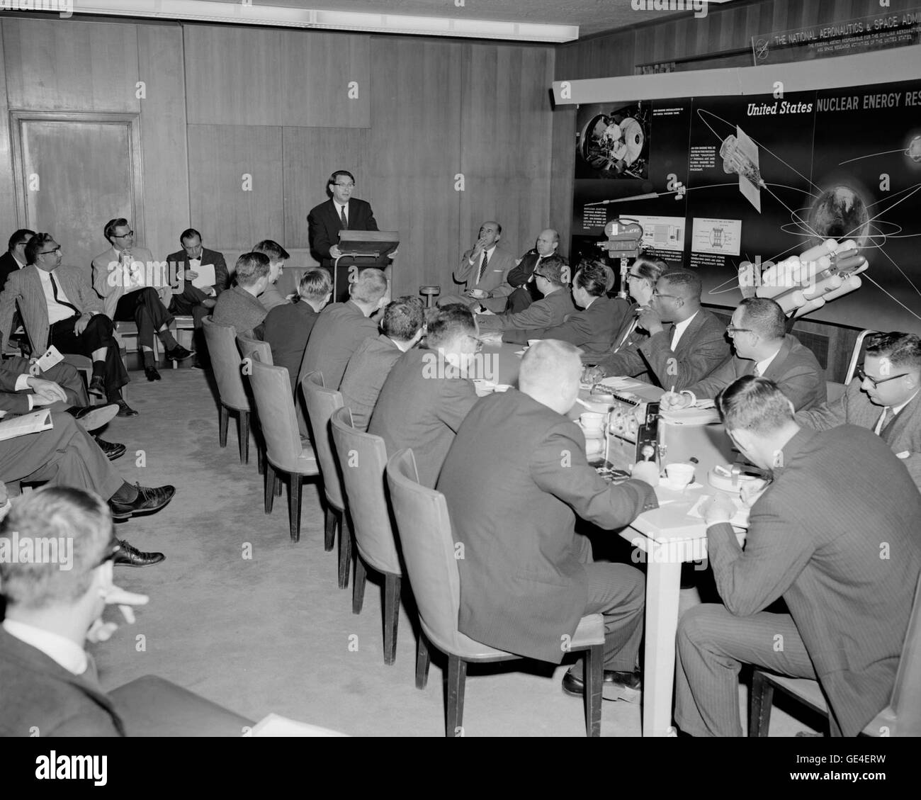 Abe Silverstein, director of Lewis Research Center, addresses an audience about the benefits of nuclear propulsion. In the background is a display titled &quot;Nuclear Energy Research Technology&quot; that features images of nuclear rockets and uses for thermoelectric power.  Image # : C-1961-58359 Stock Photo