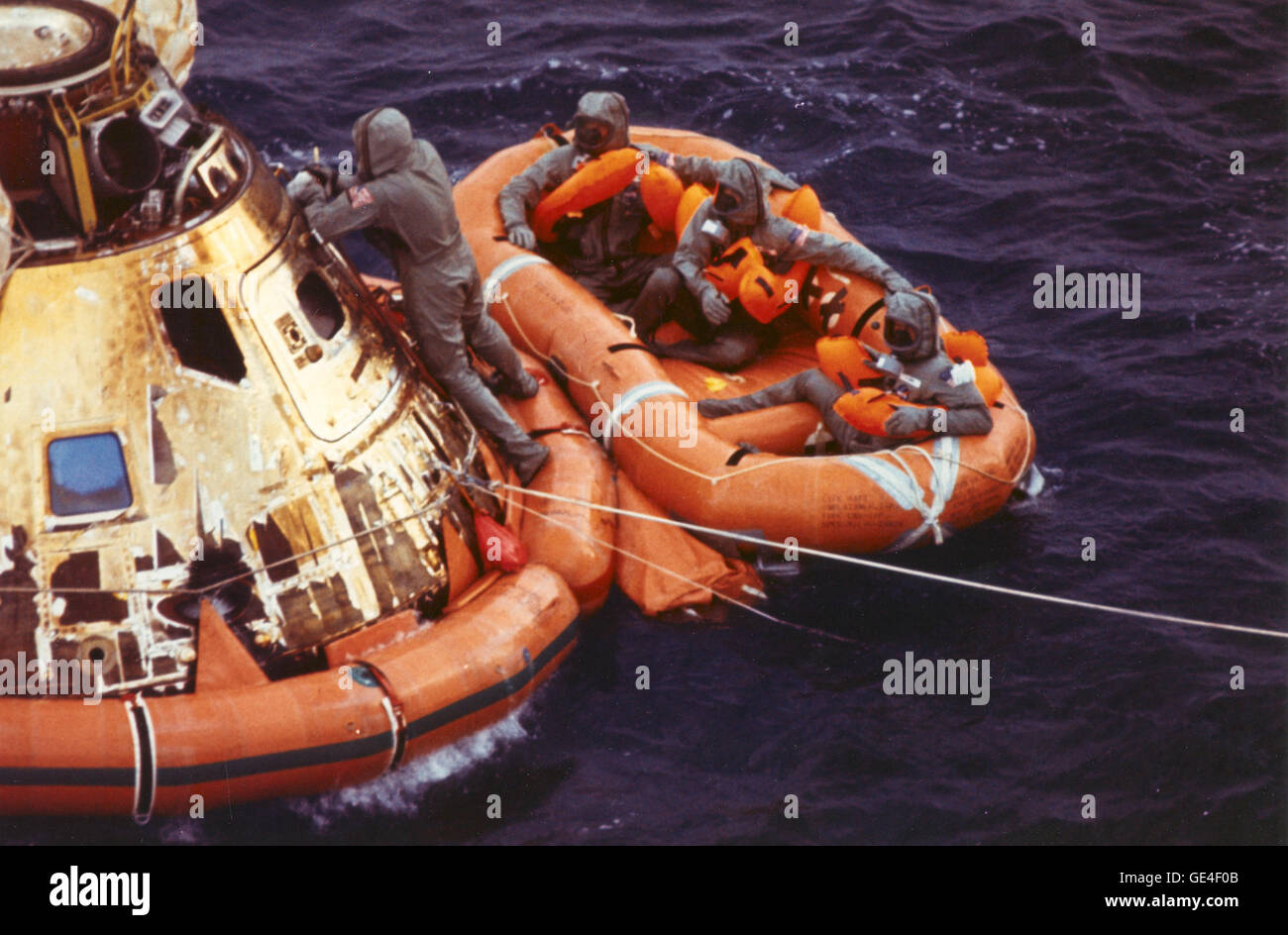 (July 24, 1969) Pararescueman Lt. Clancy Hatleberg closes the Apollo 11 spacecraft hatch as astronauts Neil Armstrong, Michael Collins, and Buzz Aldrin, Jr., await helicopter pickup from their life raft. They splashed down at 12:50 pm EDT July 24, 1969, 900 miles southwest of Hawaii after a successful lunar landing mission.  Image # : 108-KSC-69PC-452 Stock Photo